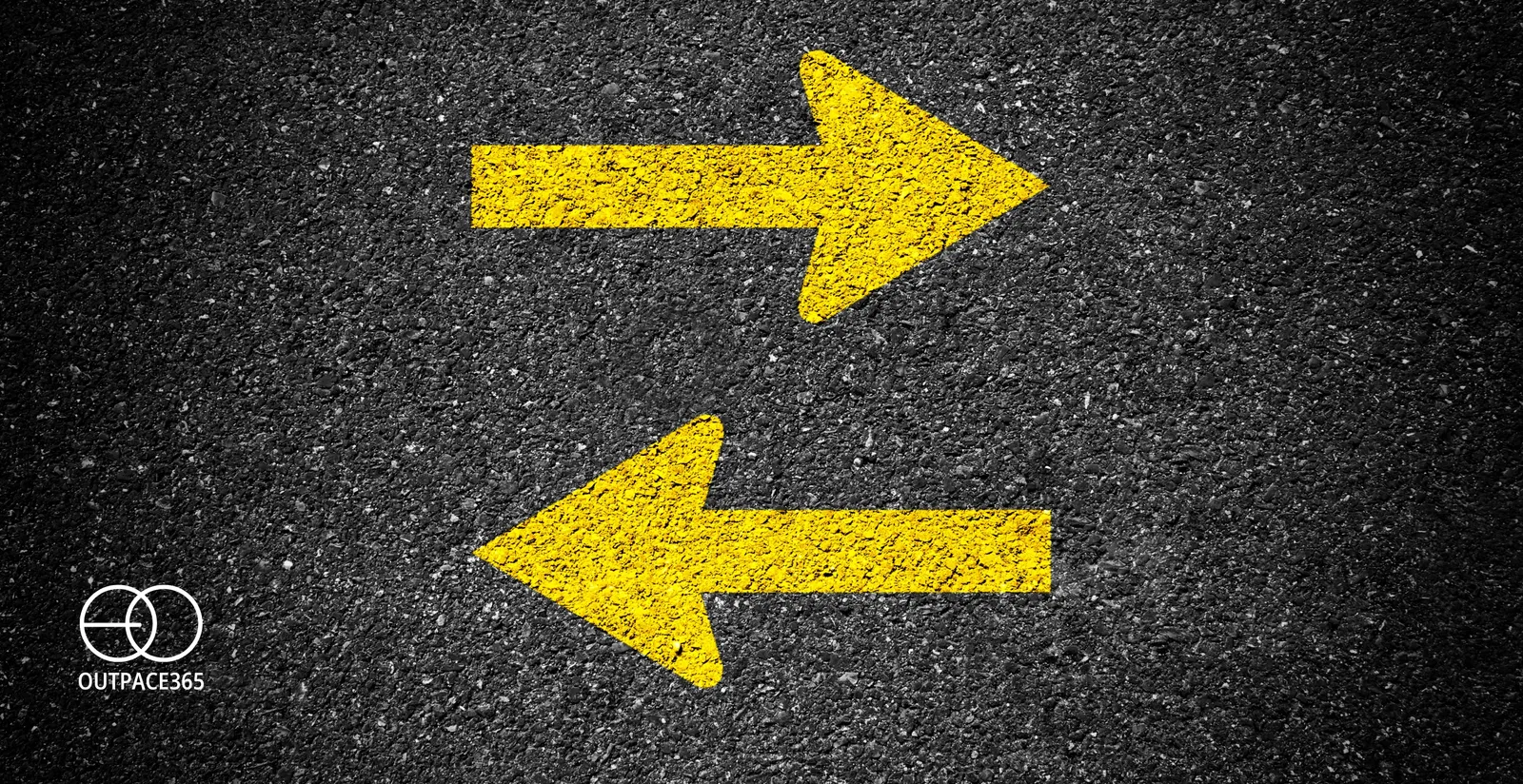 Two yellow arrows painted on asphalt, pointing opposite ways