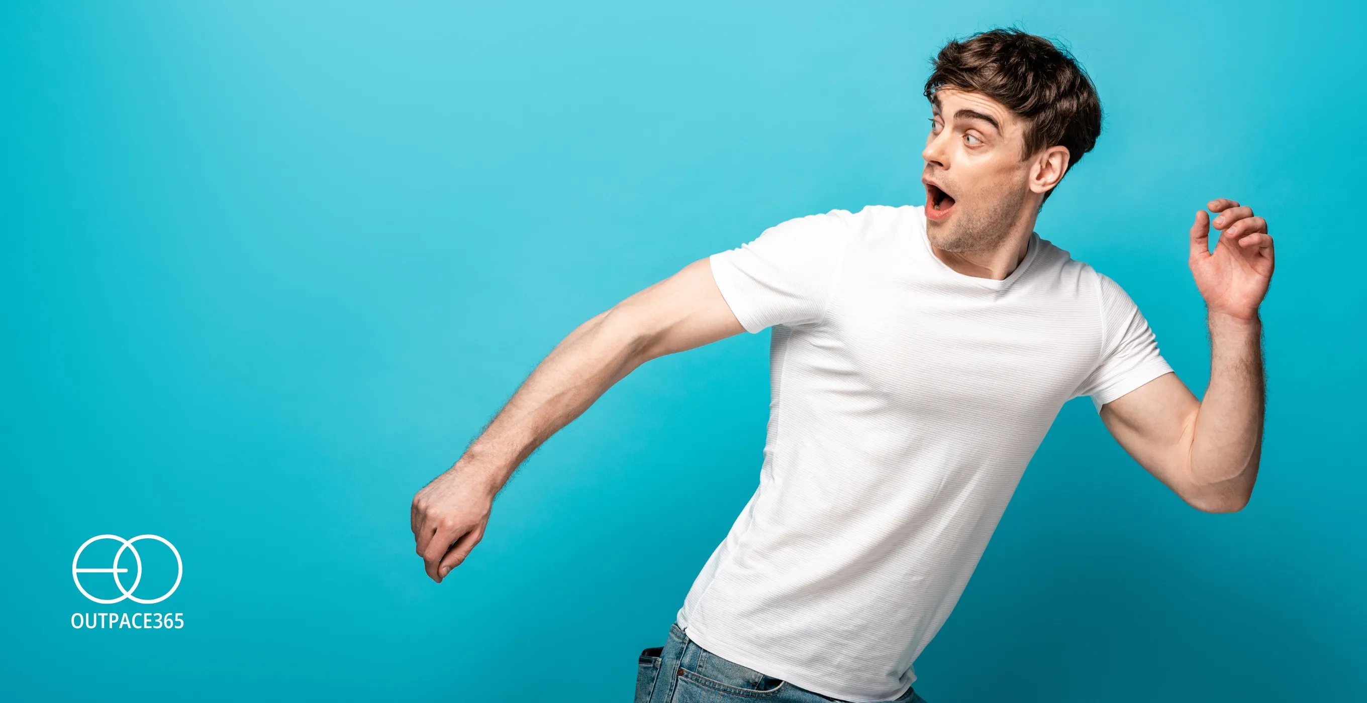 A man mid-stride, turning away against a turquoise background